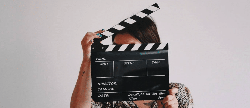 someone holding a film clapboard in front of their face