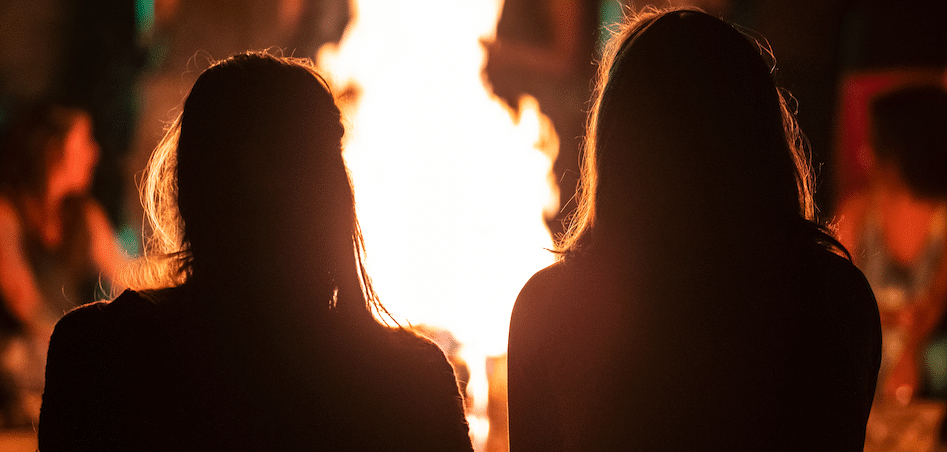 two women in front of a fire